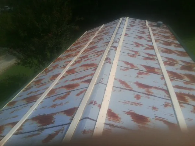 Rusted metal roof panels with new wood purlins before replacement — Storm Damage Roof Repair in Monessen by Roofing Brothers