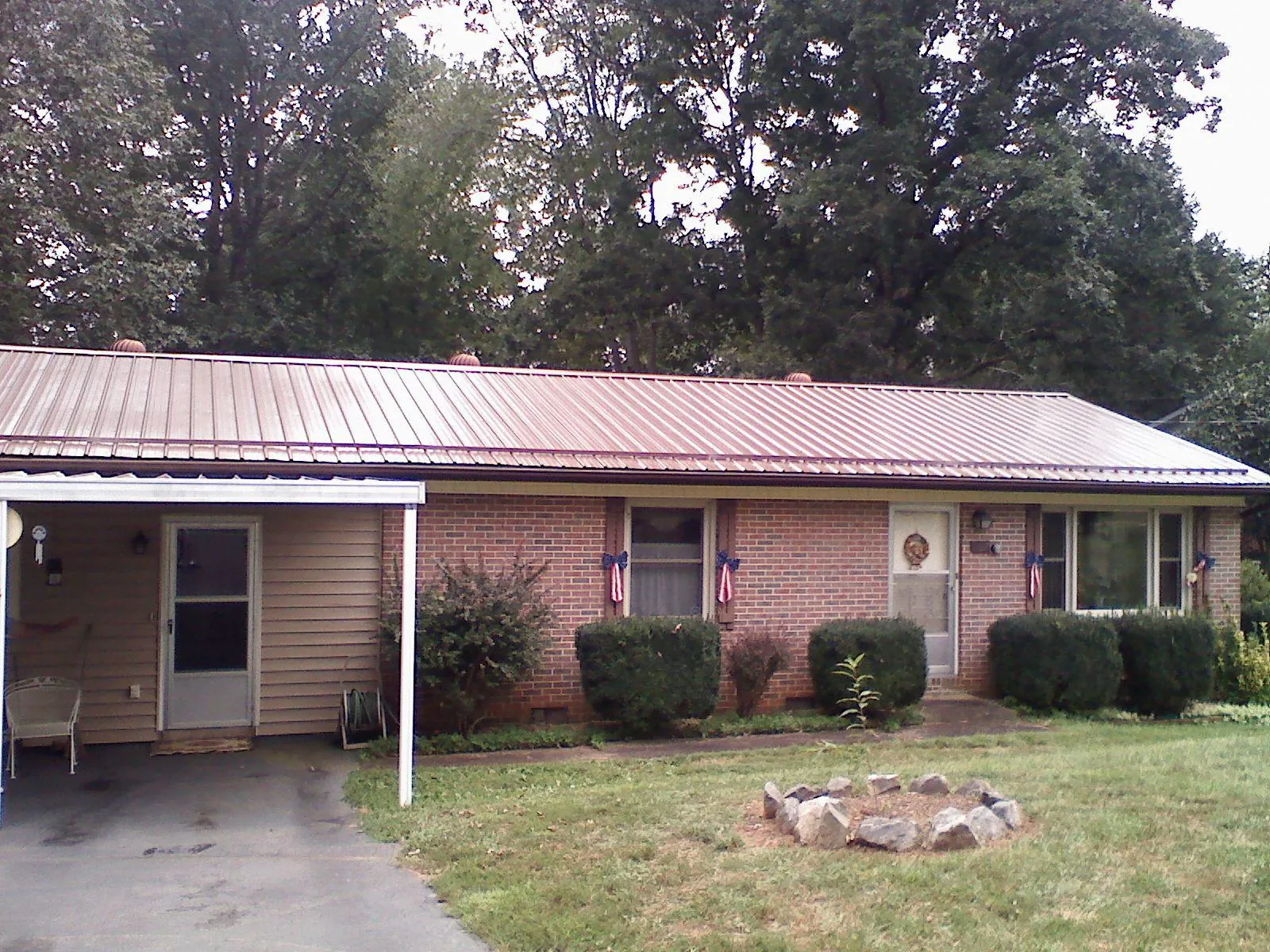 Bronze metal roof and carport on a brick ranch home — Roof Repair work by our crew in Monessen