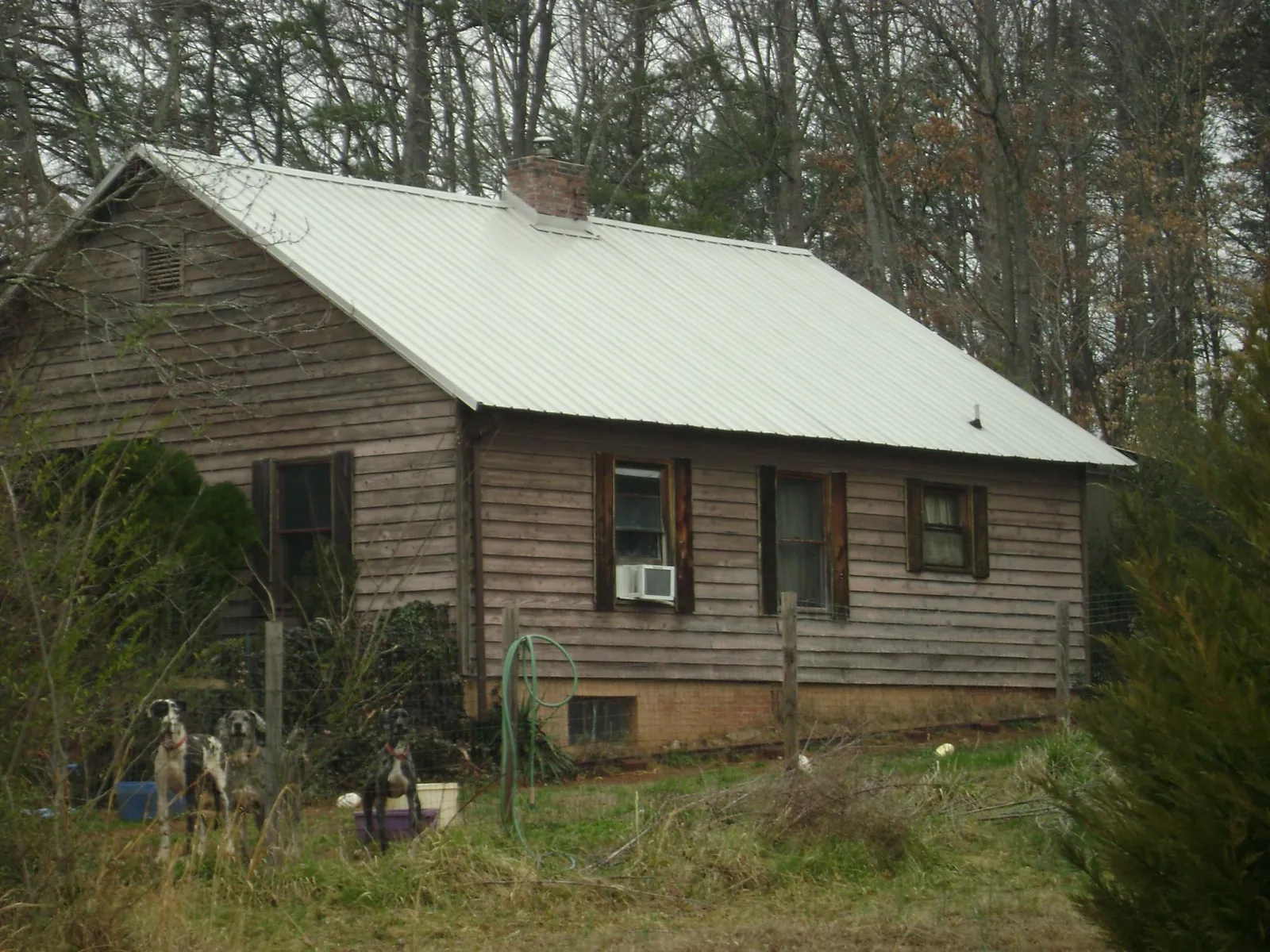 White metal roof on an old wood sided farmhouse, from a Metal Roof Installation job in Monessen